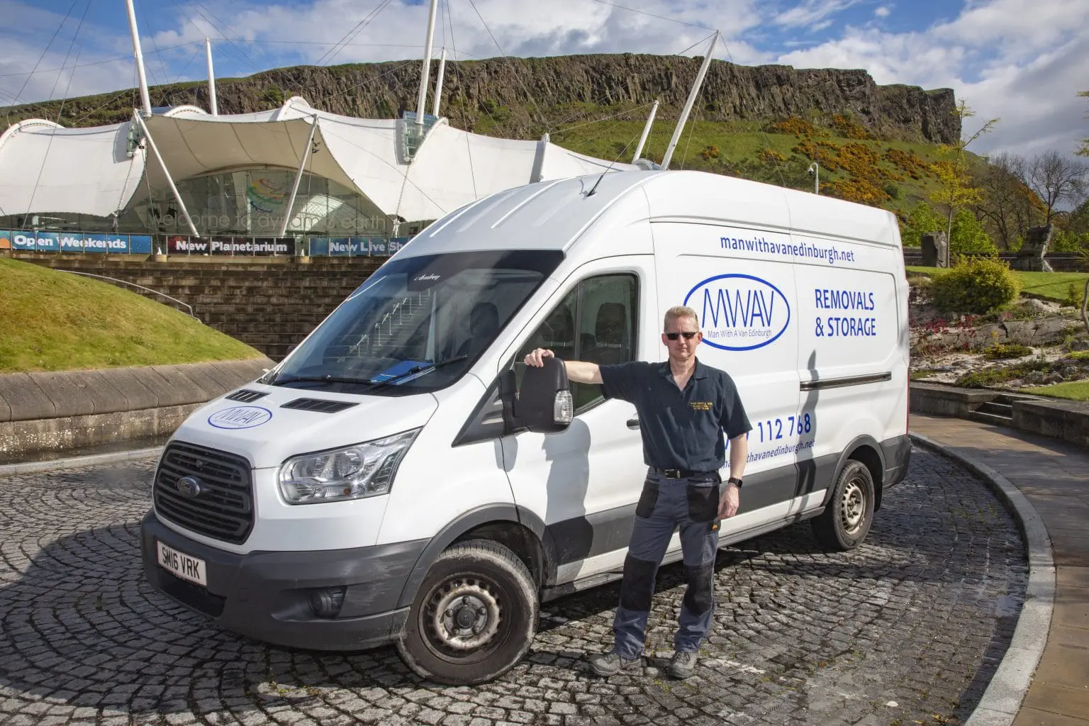 man with a van parked on the side of a road